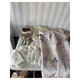 Baby quilt has stains, crocheted boots, hat, and