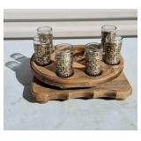six decorative shot glasses housed in a wooden
