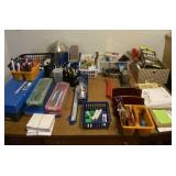 All office supplies on desk including a whole lot