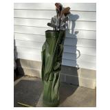 Green golf bag with golf clubs.