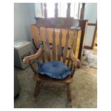 Solid wood rocking chair with cushion.