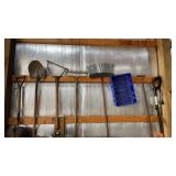 Tools on wall, shovels, rakes, electric trimmer,