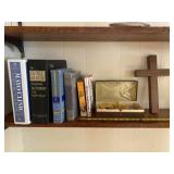 Wood cross, dice, dictionary and books on shelf.