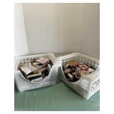 Two white Plastic Baskets Full of Makeup.
