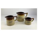 (3) stoneware measuring pitchers set