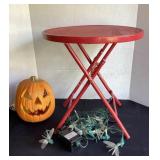 Red metal folding table, lighted pumpkin &