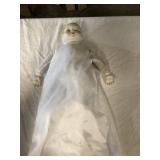 Porcelain doll, tear in left arm. A couple