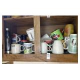 Bottom shelf of cups and mugs