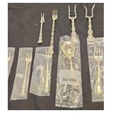 8 serving forks and a serving spoon of different