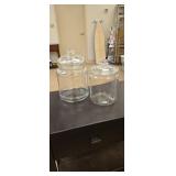 Pair of clear canisters approx 10 and 8 inches