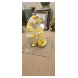 Yellow and white ceramic cat on glass she is