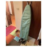 Two vintage electric irons and a ironing board.