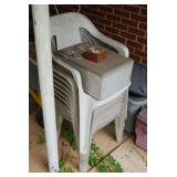 Stack of Plastic Outdoor Chairs with Storage Container