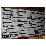 Assorted Metal Farm Implement Wrenches and Hand Tools on Pegboard Display