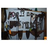 Collection of Cast Iron Farm Implements, Chains, and Tools Displayed on Pegboard