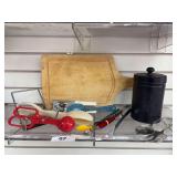 Miscellaneous kitchen utensils, black metal canister , and wooden cutting board