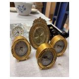3 small gold leaf painted Quartz clocks , medium sized gold tone Bulova clock , one clear glass clock , opera glasses in case and mother of pearl opera glasses in velvet pouch , sachet