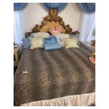 Ornate carved gold tone upholstered frame headboard on complete king size bed