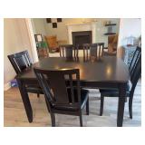 Dining room table with 5 cushioned chairs and an extra leaf