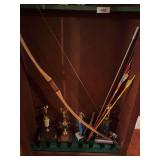 Contents in gun cabinet, bow and arrows, sling shot, trophies, miscellaneous