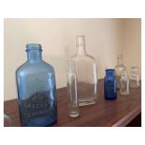 Collection of old bottles and a Saratoga sparkling water bottle