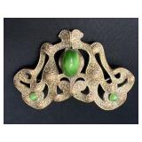 Ornate brass sash brooch with green glass stones