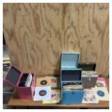 Assortment of 45 RPM vinyl records with album book