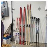 Three Pairs Of Skis And Two Sets Of Ski Poles. Ski