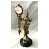 Swinging clock featuring a bronze-patinated