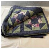 Handmade patchwork quilt featuring blue, green,