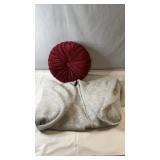 Decorative round red accent pillow paired with a