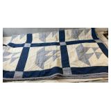 Handmade quilt featuring blue, white, and light