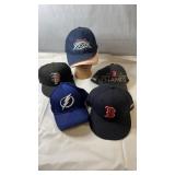 Assorted sports team hats including Boston Red