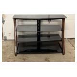 Black glass TV stand featuring multiple tiered