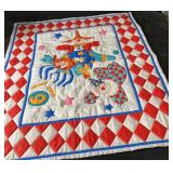 Colorful handmade baby quilt featuring playful