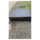 Storage ottoman featuring a dark brown faux