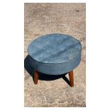 Round upholstered footstool with tufted blue