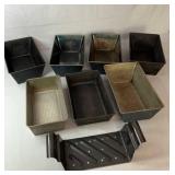Collection of seven metal loaf pans in assorted