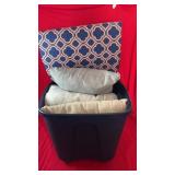 Plastic storage bin filled with assorted throw