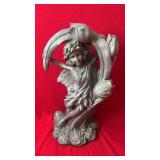 Decorative fairy figurine seated beneath a floral