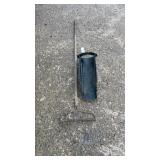 Long-handled garden rake paired with a black leaf