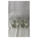 Set of four matching clear glass tumblers with a
