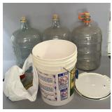 Three large glass carboys with cork stoppers,
