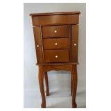 Wood jewelry armoire on raised legs with three
