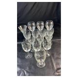 Fifteen clear drinking glasses in various sizes