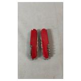 Two red multi-tool pocket knives with various