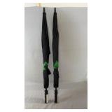 Two black golf umbrellas with green accent