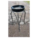 Raised black metal plant stand featuring a round