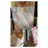 Box containing a variety of decorative gift bags,
