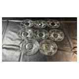 Set of eight clear glass saucers featuring an